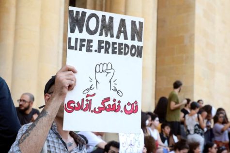 Person holding up sign that reads, woman, life freedom