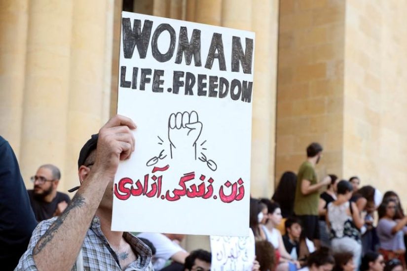 Person+holding+up+sign+that+reads%2C+woman%2C+life+freedom